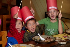 a group of kids wearing paper buckets