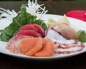 a plate of raw fish and vegetables