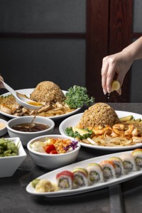 a person pouring lemon juice on a plate of food